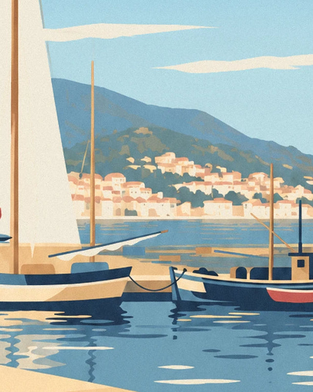 Sailing boats and a rowing boat moored in the harbour, with pale houses on the hill in the background