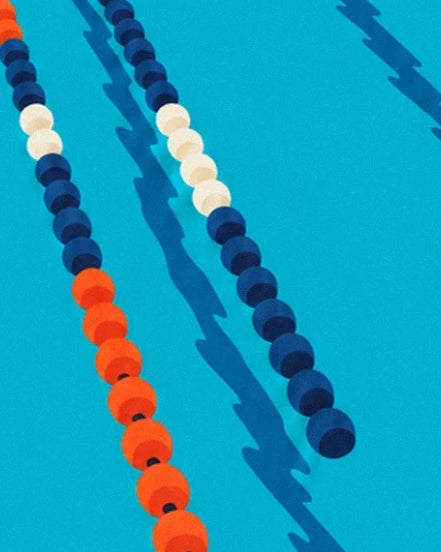 The navy blue, white and orange floats and their shadows in the turquoise water