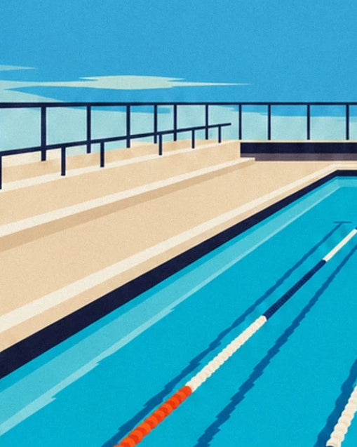 The beige spectator stands and dark railings beside the turquoise pool