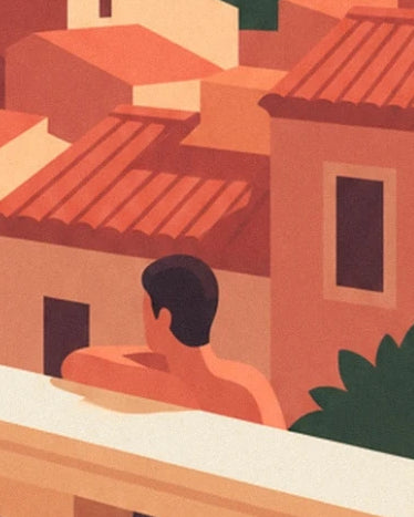 A figure seen from behind beyond a pale balustrade, facing houses with red tiled roofs