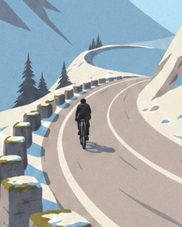 Ein Radfahrer auf der kurvigen Passstraße, gesäumt von Schnee und Steinmarkierungen