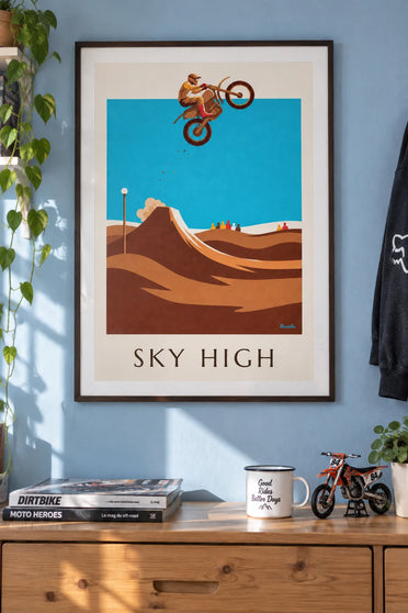 Poster of a motocross rider mid-jump above the track: framed on a wall