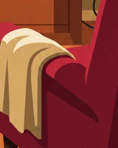 The cream throw draped over the arm of the burgundy armchair