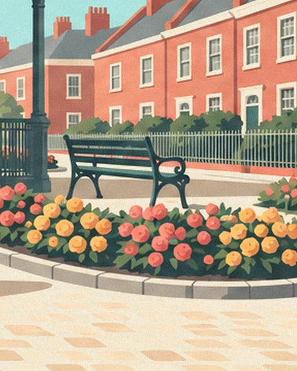 A green bench bordered by pink and yellow flowers, in front of the red-brick façades